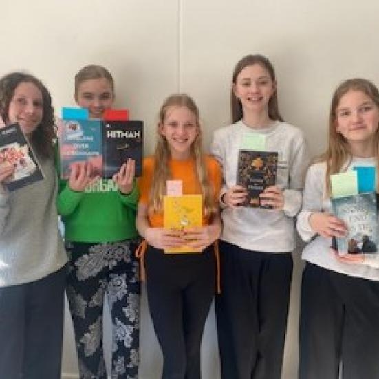 En gruppe piger står sammen med bøger i hænderne