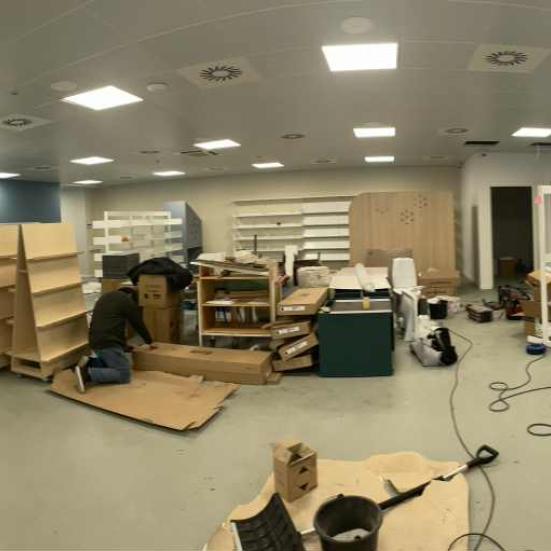 Et bibliotek under opbygning. Tomme reoler, værktøj og byggematerialer i et tomt lokale.