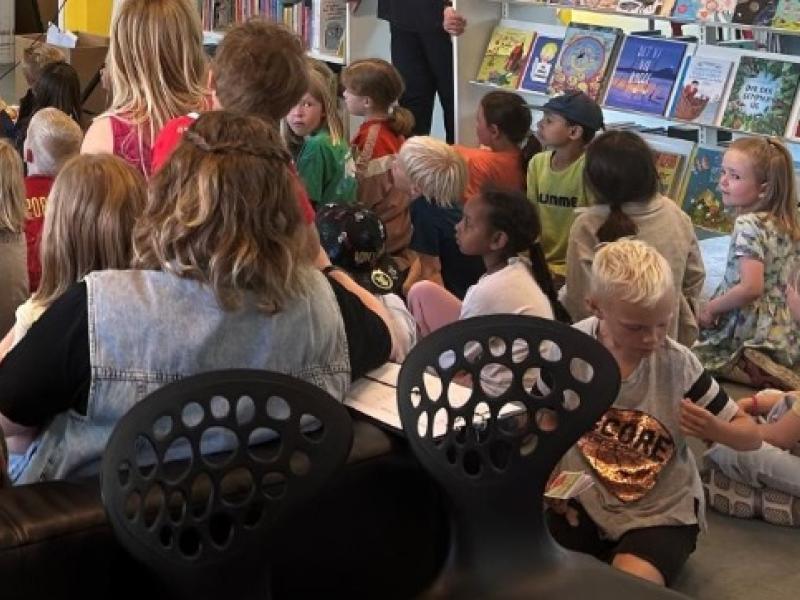 Billede af børn og voksne der får læst højt.