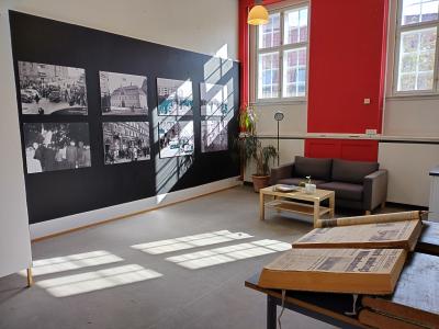 Udstillingen hos HistorieAalborg. En væg med billeder i sort hvid i baggrunden og i forgrunden dagens avis fra den 9. april 1940