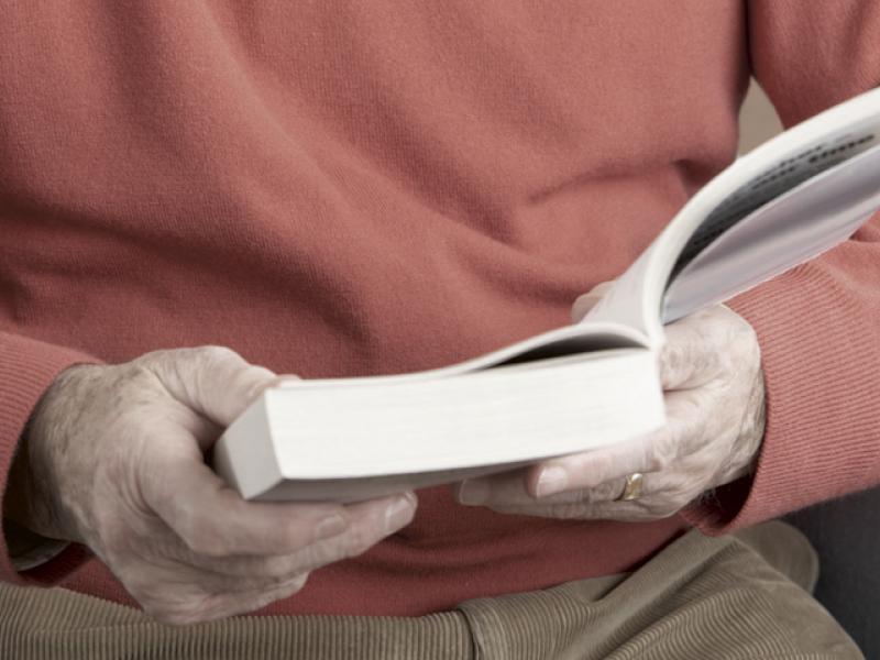 Nærbillede af mand der sidder og læser 