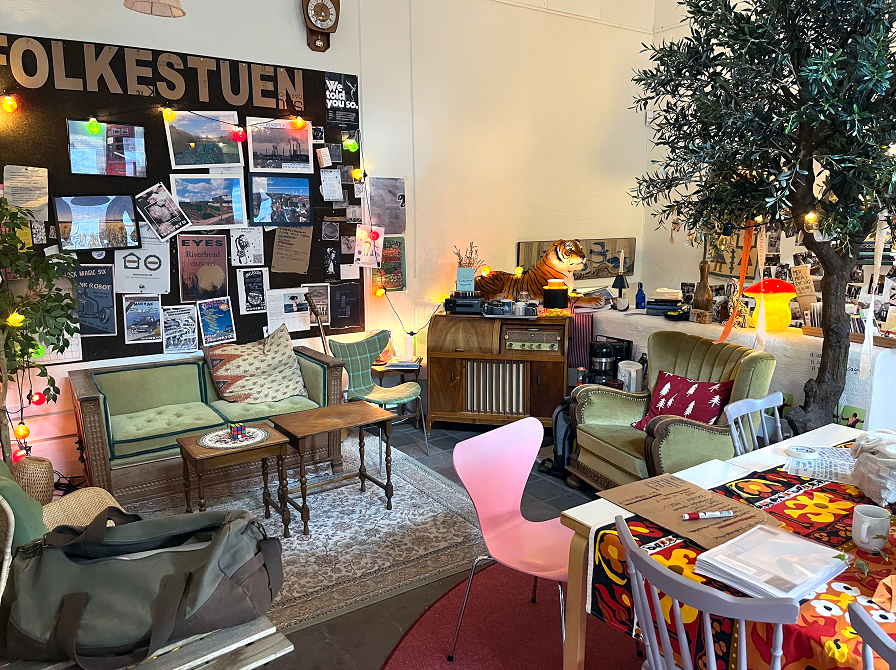 Folkestuen på hovedbiblioteket. Et rum med gamle møbler, mange billeder på væggene og tæpper på gulvet. 