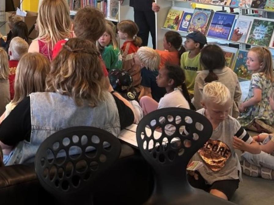 Billede af børn og voksne der får læst højt.