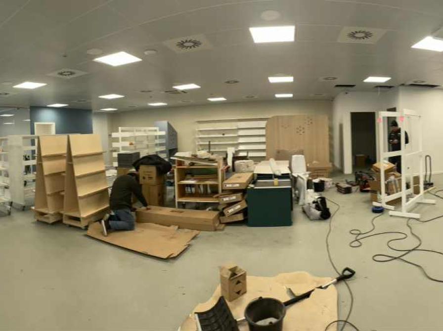 Et bibliotek under opbygning. Tomme reoler, værktøj og byggematerialer i et tomt lokale.